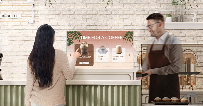 At a café, a woman is selecting from the menu by touching the Transparent OLED Signage screen.