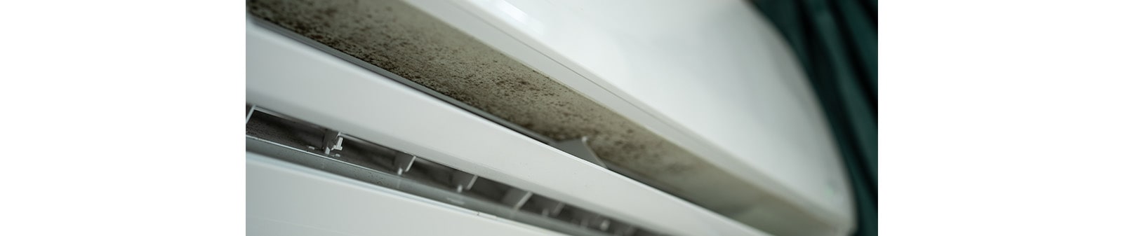 A white air conditioner with mold