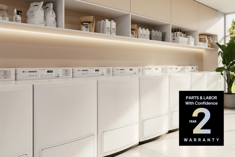 A row of modern, white washing machines in a laundry room. The machines are neatly arranged with shelves above them holding laundry detergent and other supplies.