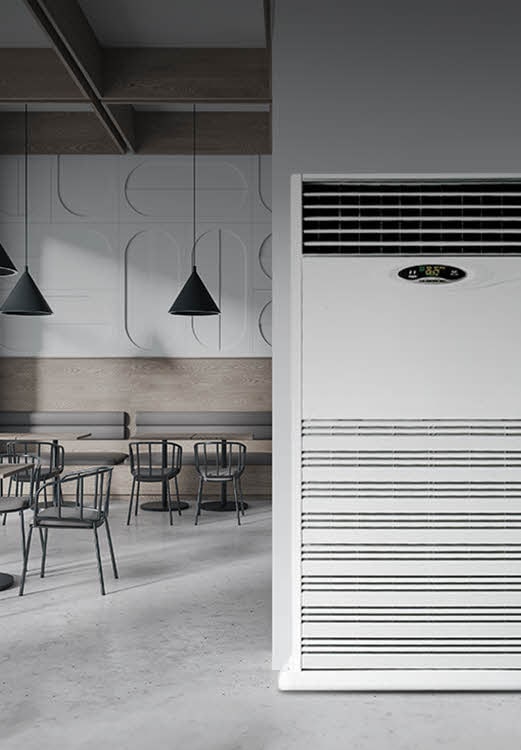 Close-up view of a large floor-standing air conditioner placed in a minimal commercial space, designed for high-capacity cooling in open public environments.