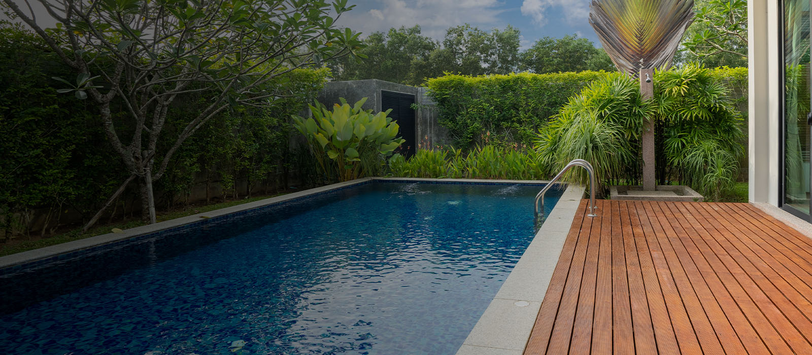 swimming pool and decking in garden of luxury home
