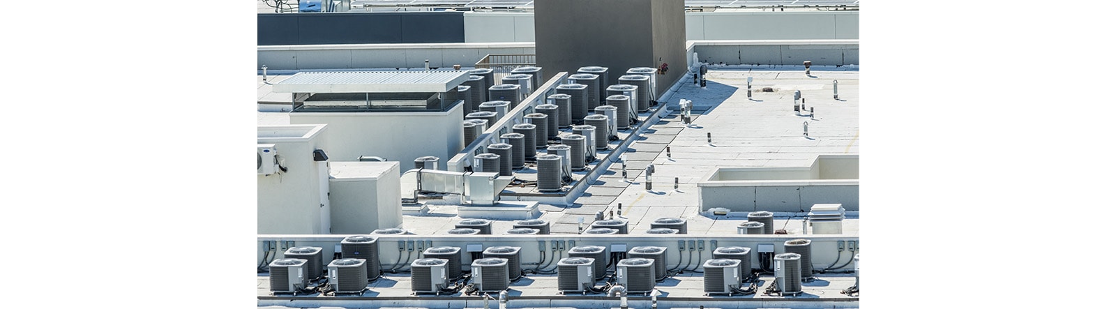 An overhead view of a densely packed commercial rooftop, dominated by numerous HVAC units.