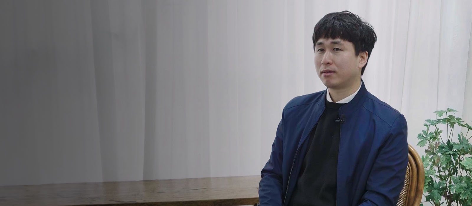 A man wearing blue jacket sitting on a chair