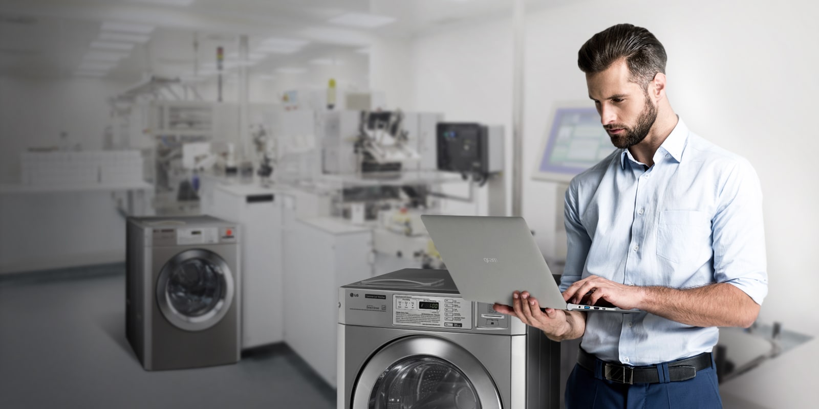 A professional using a laptop in a commercial laundry room