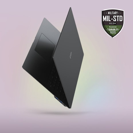 A sleek, partially open laptop with a minimalist design, showcased against a soft gradient background. The MIL-STD durability certification badge is prominently displayed in the top right corner, emphasizing its slim, lightweight, yet durable build.