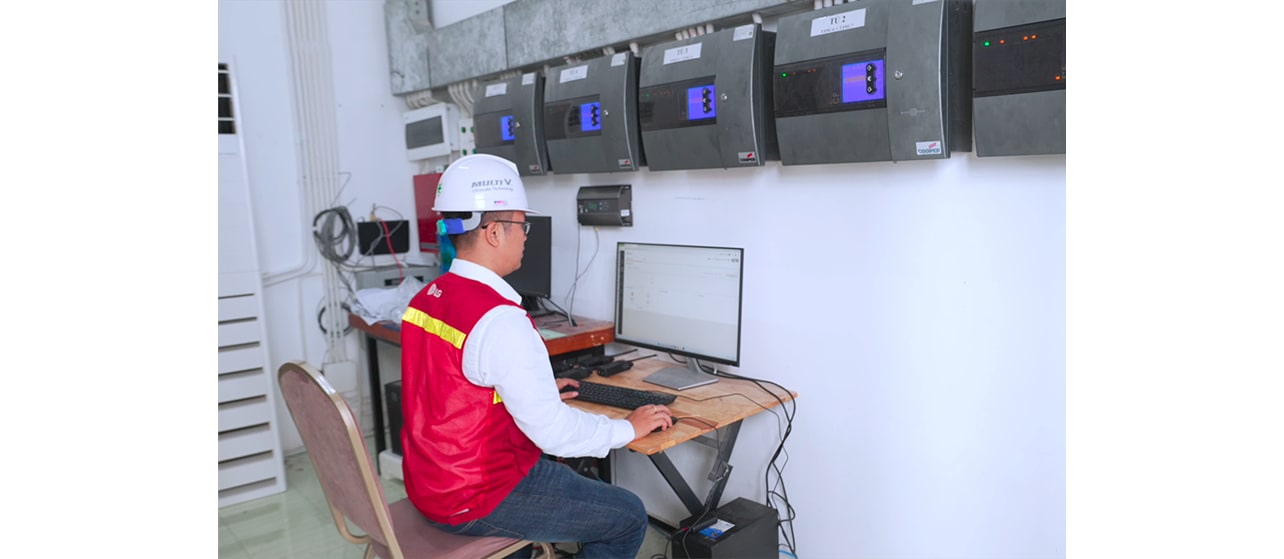 An employee is standing in front of a computer, monitoring