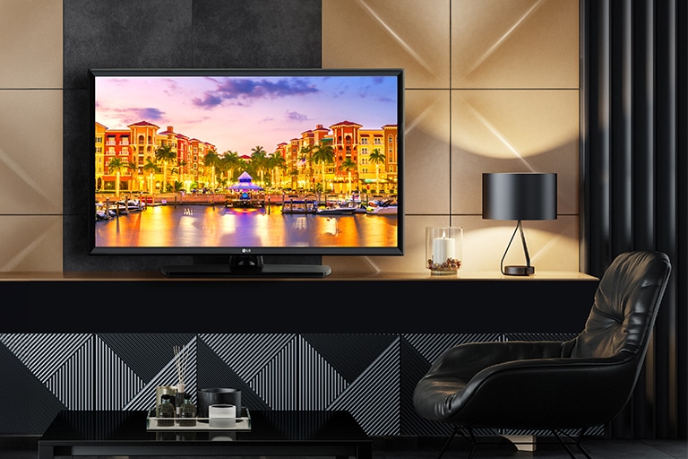 A TV is installed in the hotel room, and a vivid sunset scenery is displayed on the screen.