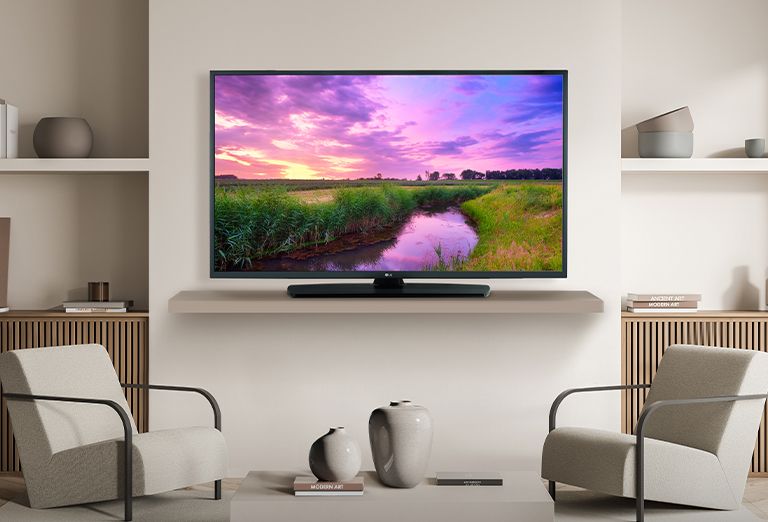 A TV on a hotel’s wall shows a bright and vivid screen.