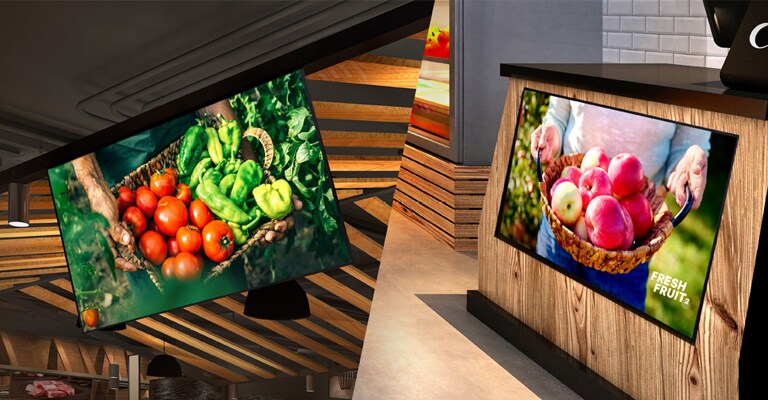 One UL5Q-E is installed on the store ceiling with a down tilt, and the other is mounted below the counter with an up tilt, both displaying content.