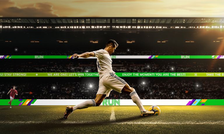 A soccer match is in progress at the stadium, and the GRPA series is installed along the railing walls of the second and third-tier stands, playing advertisements on the screen.