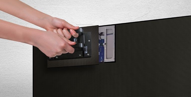 A person replaces one of the LED modules from the front by using the magnetic tool provided.