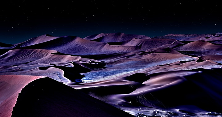 The contrast between light and shadow is detailed and distinct across the red desert landscape under the dark night sky.