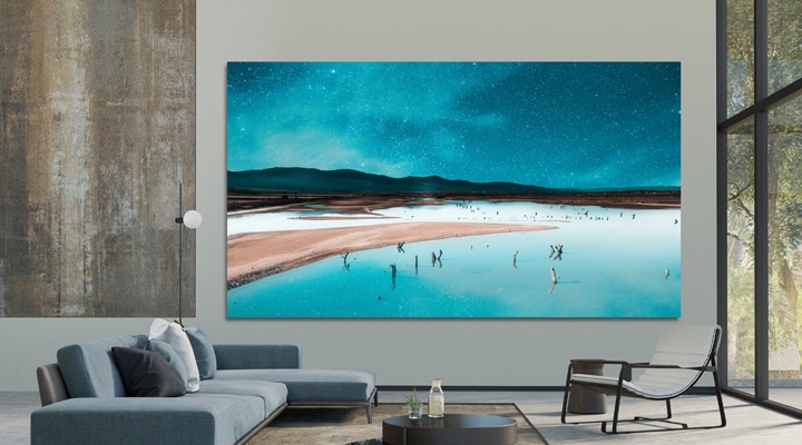 LG MAGNIT Active Micro LED is installed on the wall of a modern, open-space living room. Multiple display units are precisely aligned and combined into one large screen, delivering an immersive view of the landscape.