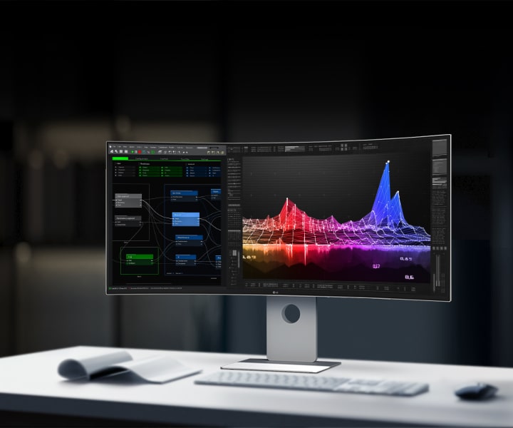 LG UltraFine monitor on a desk displaying colorful data visualizations and coding interface in a modern office setting.
