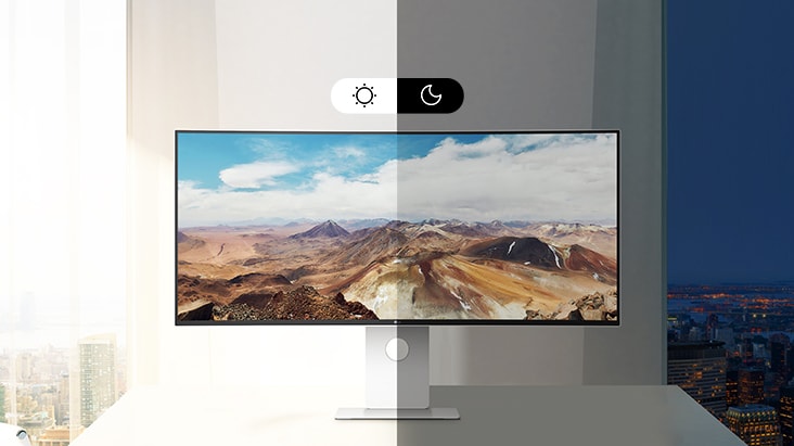 UltraFine monitor displaying a landscape image, with a split-screen effect showing day mode on the left and night mode on the right, highlighting automatic brightness adjustment.	