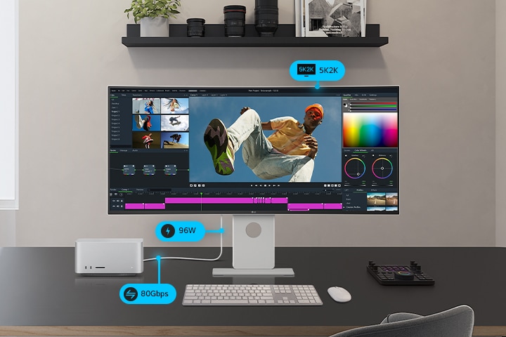 A UltraFine monitor is placed with program screen on it beside a smaller monitor, a PC and a storage, connected with cables showing its multi-connectivity.