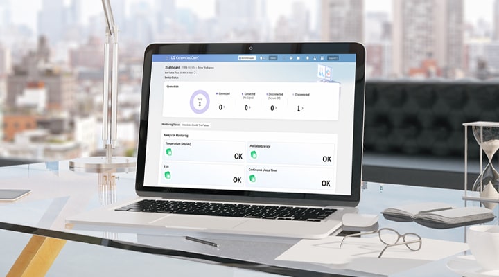 On the desk, a laptop displays the LG ConnectedCare (DMS License) dashboard on its screen.
