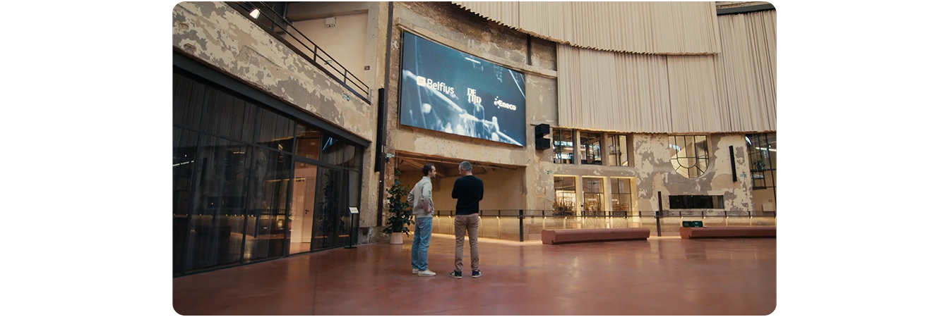 Wintercircus Ghent's operations lead speaking on camera in the mezzanine area with the LG 298-inch Indoor LED Wall in the background