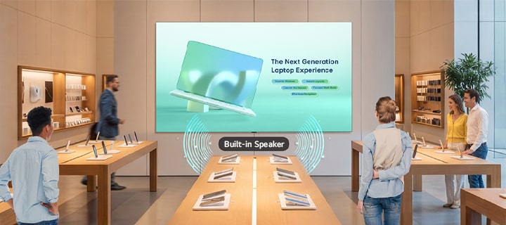 A large LASA136 screen mounted on the wall of an electronics store displays a product advertisement, with sound playing through its built-in speaker.