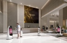 LG digital signage and AI robots in hotel lobby delivering guest services. LG hospitality solutions combining interactive displays with smart automation.