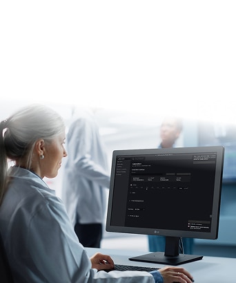 Healthcare professional reviewing patient data on an LG medical display monitor in a hospital setting for accurate diagnostics.