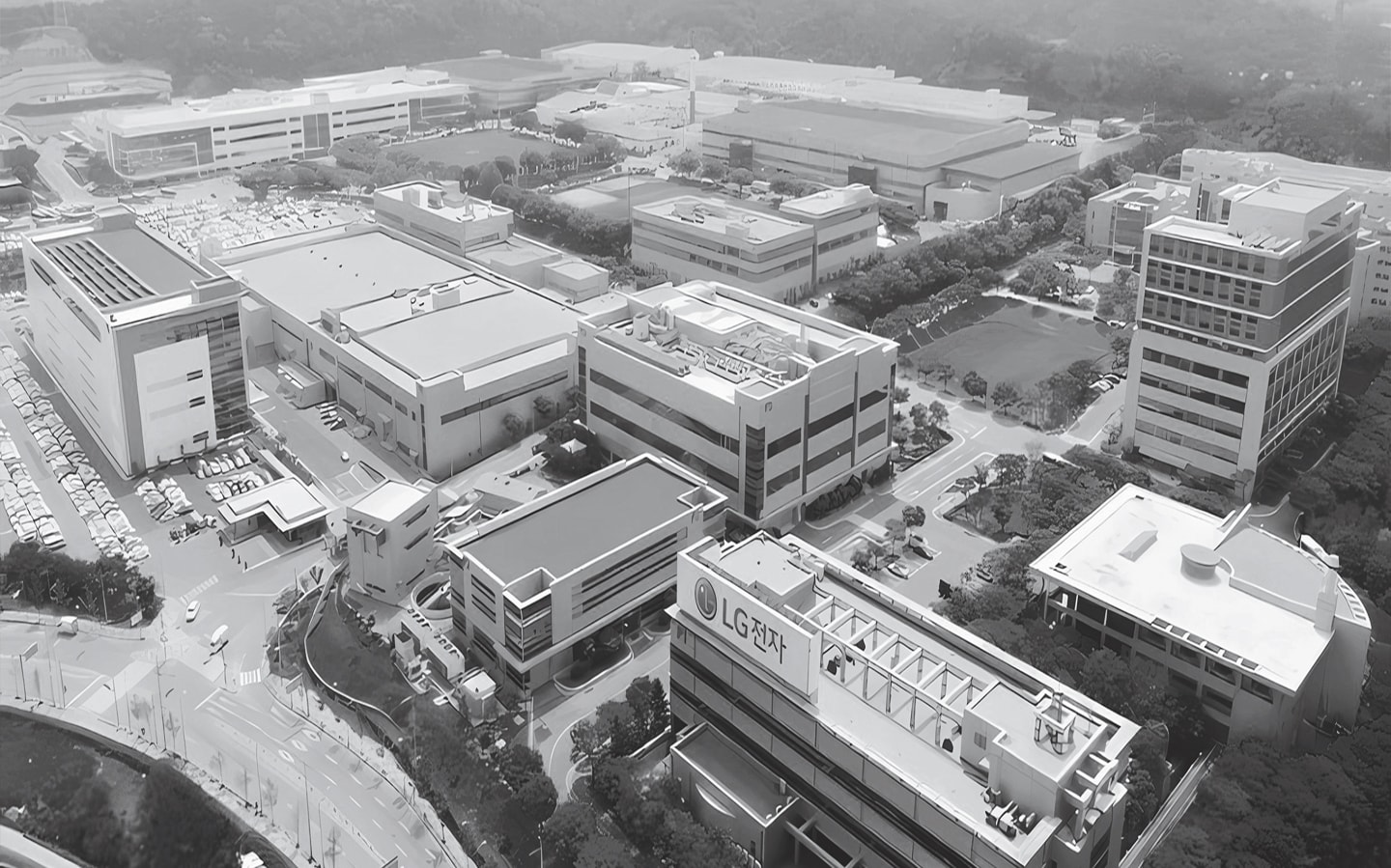 Aerial view of LG Electronics industrial complex with multiple factory buildings, parking lots, and green spaces."