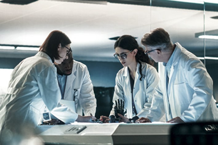 LG engineers in lab coats collaborating on production engineering research and development to optimize manufacturing processes