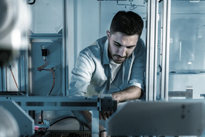 Technician inspecting equipment with laptop for predictive maintenance and upgrades, powered by LG lifecycle management solutions
