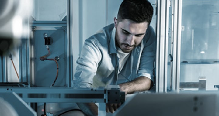 Technician inspecting equipment with laptop for predictive maintenance and upgrades, powered by LG lifecycle management solutions