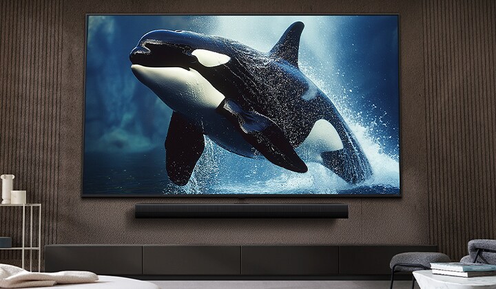 TV LG dengan layar yang sangat besar dipasang di dinding di atas soundbar LG dalam ruang tamu bergaya modern.