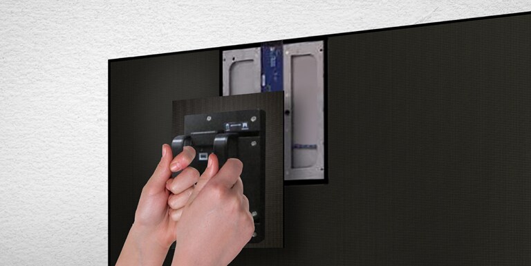 Seseorang mengganti salah satu modul LED dari depan dengan menggunakan alat magnet yang disediakan.
