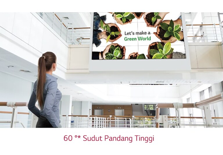 Seorang wanita melihat ke layar yang dipasang di lantai atas.