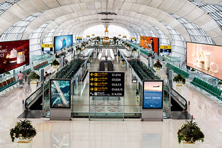 This image captures various content playing on multiple displays inside an airport.	