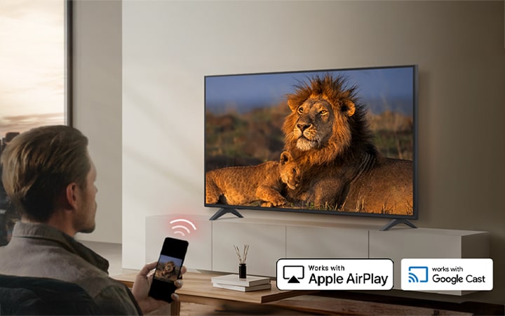 A hotel guest is casting content from a smartphone to the in-room TV using wireless casting technologies such as AirPlay and Google Cast.