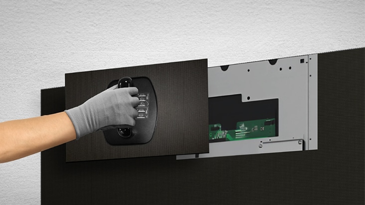 A person replaces one of the LED modules from the front using the provided magnetic tool.	