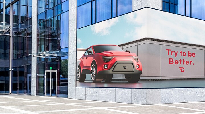 The LED screen is positioned at eye level near the bottom of the building, spanning two sides. Despite being installed across a corner, it displays content vividly without interruptions.