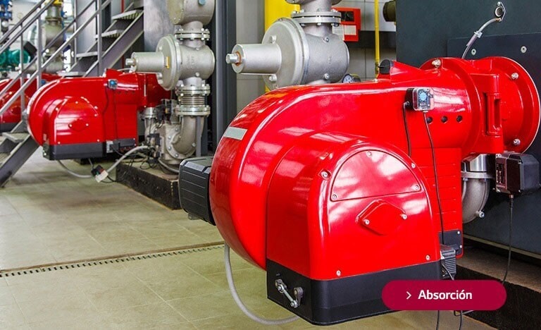 Equipos industriales de absorción con grandes compresores rojos en una sala de máquinas, decorados con etiquetas rojas que indican 'Absorción'.