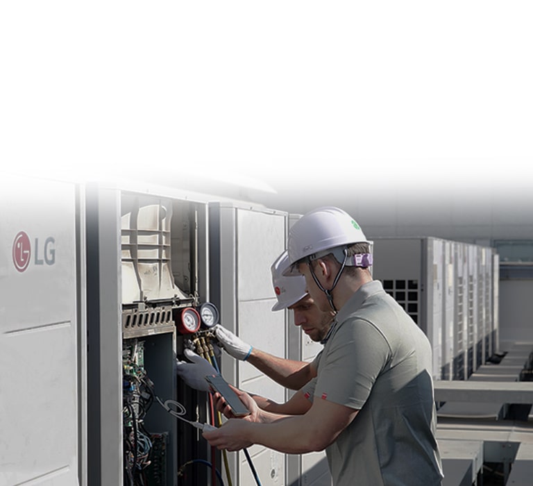 Técnicos utilizando una computadora portátil para dar servicio al equipo HVAC MULTI V de LG, mostrando la interfaz de diagnóstico inteligente durante el trabajo de mantenimiento.
