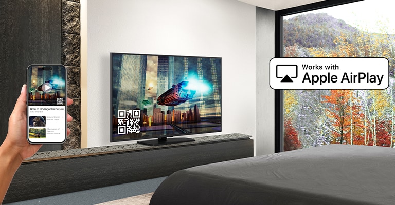 Un huésped del hotel está emparejando su iPhone con el televisor de la habitación a través de AirPlay.