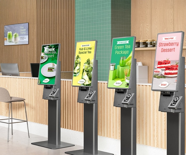 LG Kiosk & Touch self-ordering machines installed in a modern café, displaying menu options for tea and desserts. Fast and convenient LG digital kiosks enhance customer satisfaction with touch-screen ordering solutions.