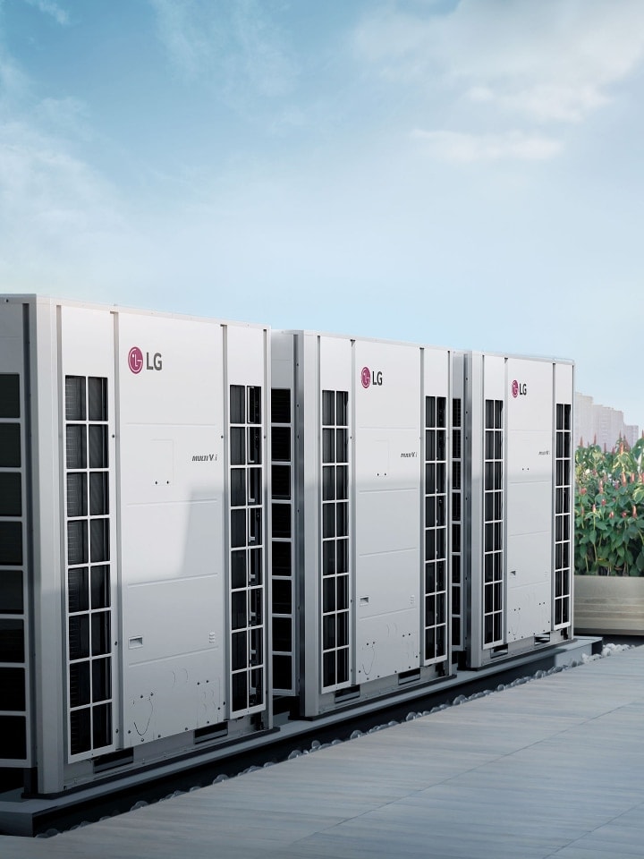 Trzy urządzenia LG Multi V, które oferują rozwiązania powietrzne w budynkach komercyjnych, są ustawione obok siebie na rogu zewnętrznego ogrodu budynku.