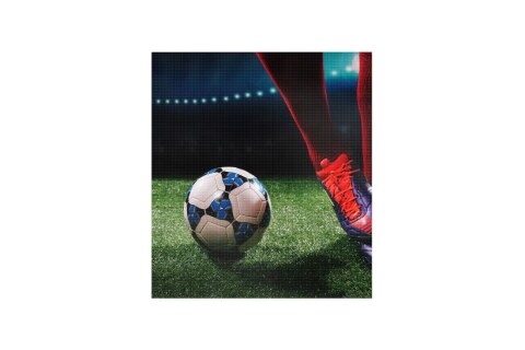 لقطة مقربة لقدم لاعب كرة قدم بجوار الكرة في ملعب مضاء بشكل ساطع، تم التقاطها على شاشة LED خارجية.