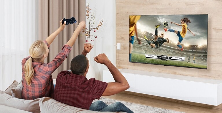 يلعب رجل وامرأة ألعاب فيديو، ويظهر مشهد اللعبة على شاشة التلفزيون بجودة تضاهي الواقع.