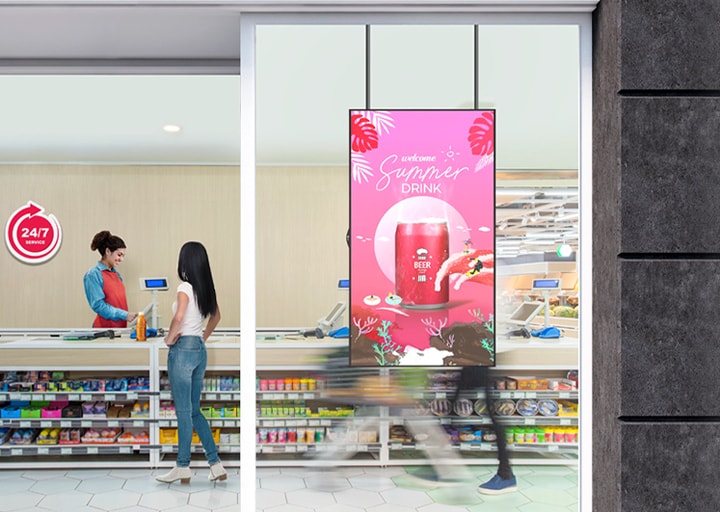 Perakende mağazasının içindeki pencereye kurulmuş geniş bir LED ekranı, cam içerisinden canlı ve parlak renklerle reklamları görüntülüyor.	