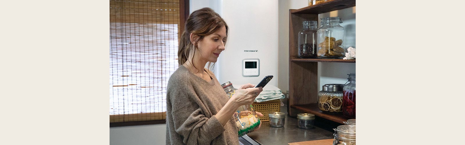 The woman is looking at her cell phone.