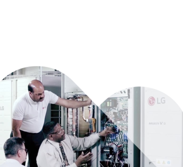 Engineers inspect an LG MULTI V i unit installed adjacent to a wall, carefully assessing its performance and key components.