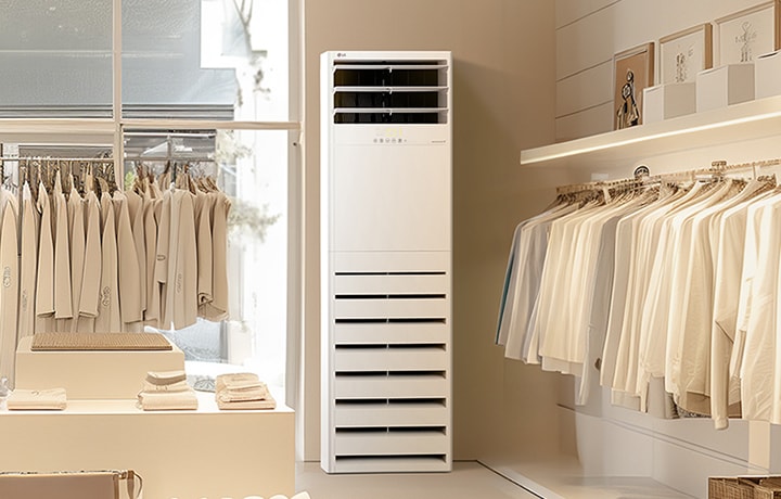 Điều hòa tủ đứng LG được đặt trong một cửa hàng quần áo tối giản có đồ màu trung tính được trưng bày gọn gàng trên giá và kệ.