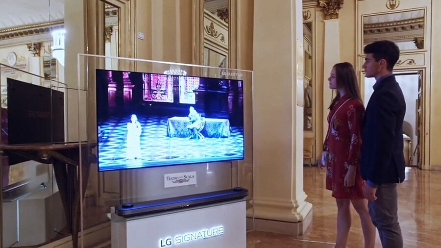 A man and woman watching the Rigoletto on LG SIGNATURE OLED 8K.