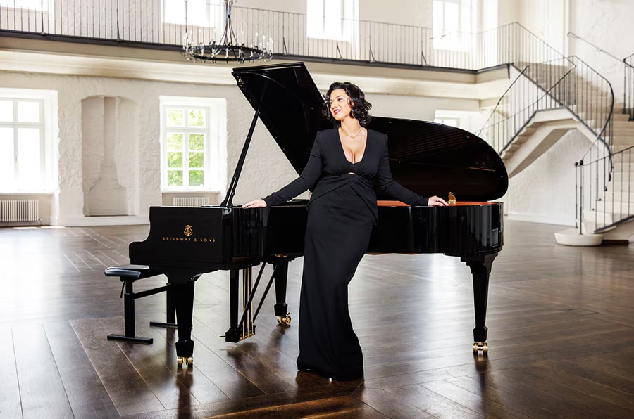 Khatia Buniatishvili next to a piano.