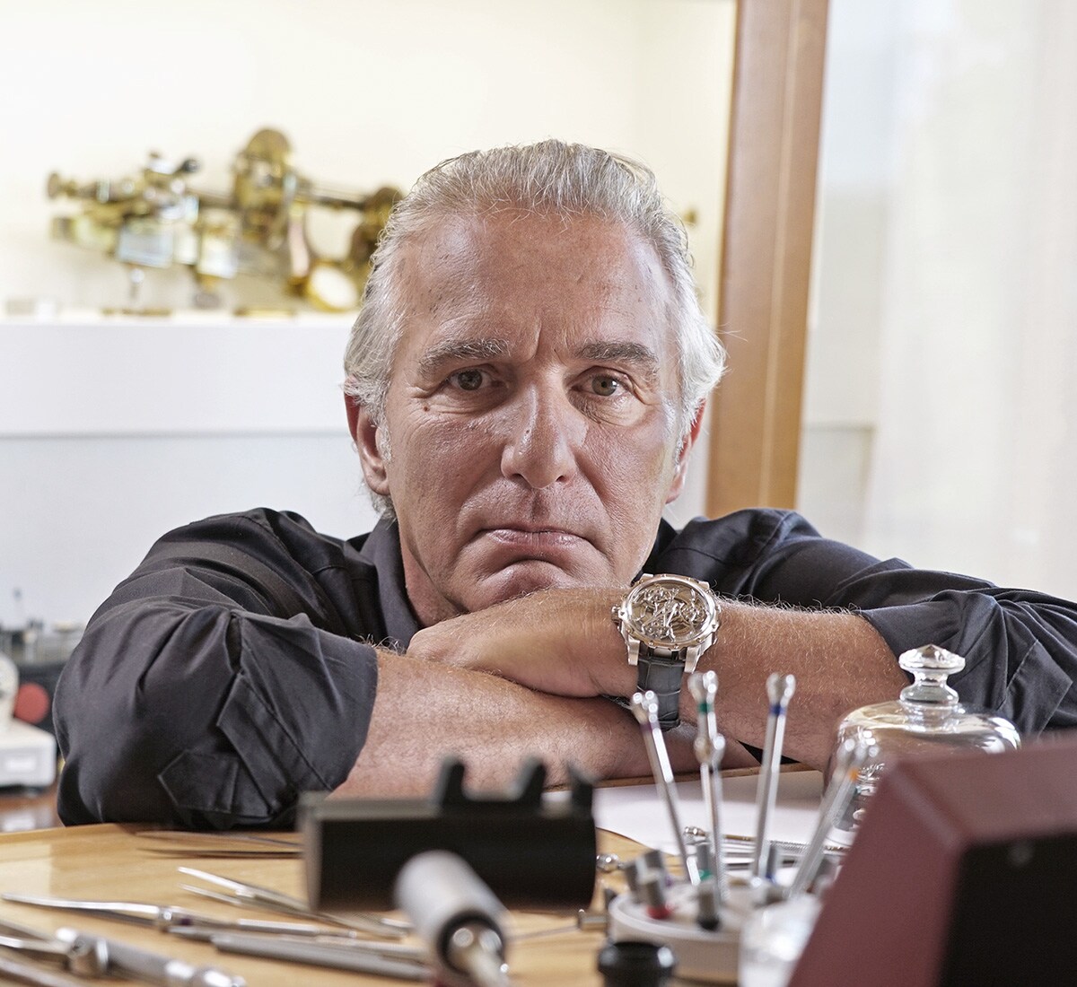 Antoine Preziuso is looking at his watch in his workspace